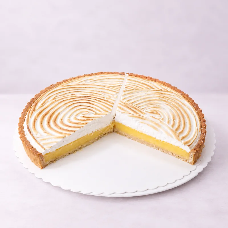 Angeschnittene Zitronen-Meringue-Tarte mit flambierter Baiserhaube